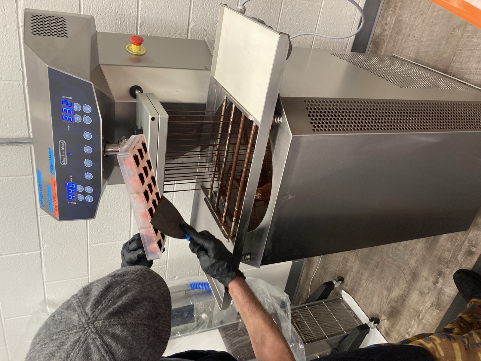 Mike working a chocolate mould by hand at the tempering machine