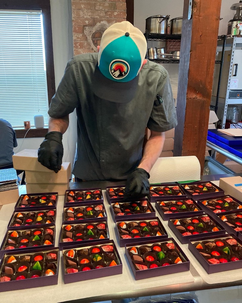 Mike carefully packing assortments of bonbons into client gifting boxes